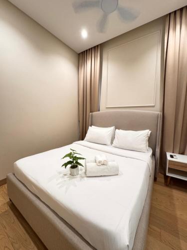 a bedroom with a white bed with a plant on it at LUCENTIA RESIDENCE By LALAPORT in Kuala Lumpur