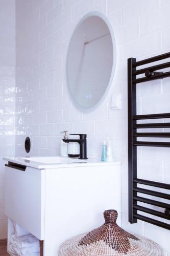 a white bathroom with a sink and a mirror at Mar-Ria 8 in Fuzeta