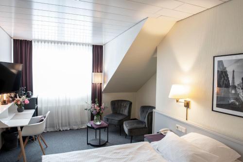 a hotel room with a bed and a desk and chair at Hotel Alte Post in Krefeld