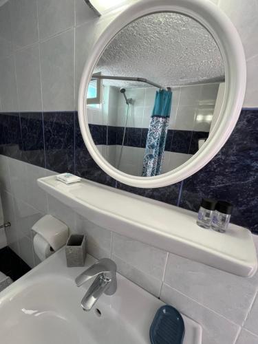 a bathroom with a sink and a mirror at Stella Nomikou Apartments in Firostefani