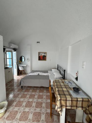 a room with two beds and a table in it at Stella Nomikou Apartments in Firostefani