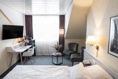 a hotel room with a bed and a desk at Hotel Alte Post in Krefeld