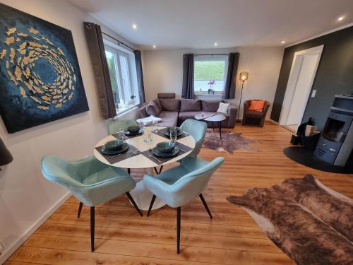 a living room with a table and chairs at Ferienhaus AKate - Sauna, Kamin, Garten, 3 Hunde in Kronprinzenkoog