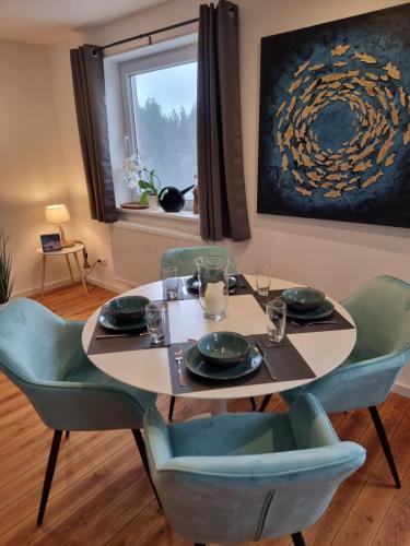 a dining room with a table and chairs and a painting at Ferienhaus AKate - Sauna, Kamin, Garten, 3 Hunde in Kronprinzenkoog
