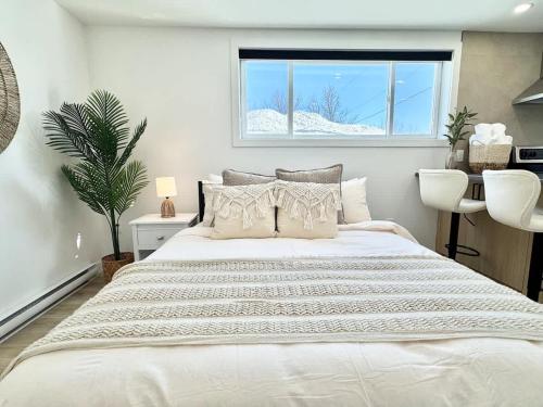 une chambre avec un grand lit blanc avec une fenêtre dans l'établissement Le Tulum 2, à Québec