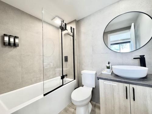 une salle de bain avec un lavabo, des toilettes et un miroir dans l'établissement Le Tulum 2, à Québec