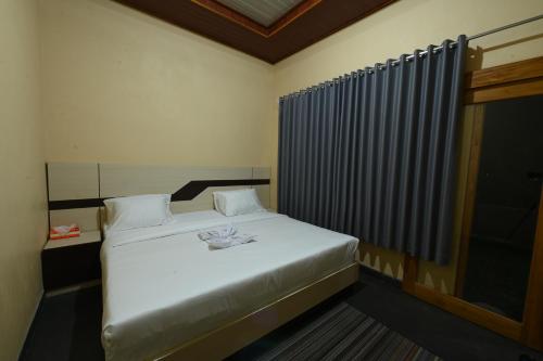 a bedroom with a white bed and a window at Pondok Alas Guests House in Gretek