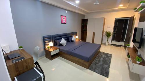 a bedroom with a blue bed and a desk at Housr 78 Madhapur Hitech City Near Yashoda Hospital in Hyderabad