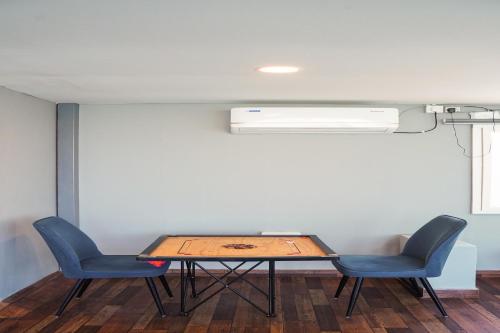 a table and two blue chairs in a room at Housr 78 Madhapur Hitech City Near Yashoda Hospital in Hyderabad