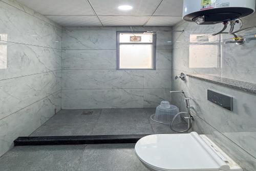 a bathroom with a toilet and a window at Housr 78 Madhapur Hitech City Near Yashoda Hospital in Hyderabad