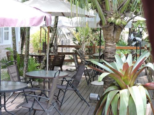 an outdoor patio with tables and chairs and umbrellas at Pousada D'amoras in Conservatória