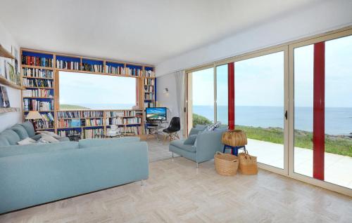 - un salon avec un canapé bleu et une vue sur l'océan dans l'établissement 5 Bedroom Stunning Home In Ploemeur, à Ploemeur