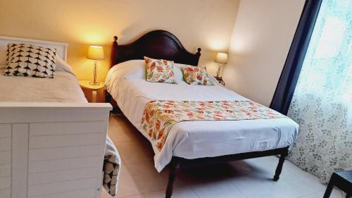 a small bedroom with a bed and a window at Chalé Seixal - Sea View in Seixal
