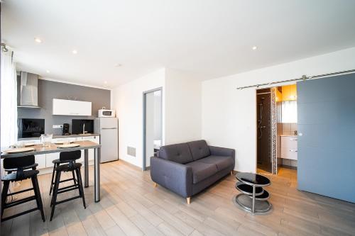 une cuisine et un salon avec un canapé et une table dans l'établissement Villa Welcom 1 - appt climatisé proche de la plage, à Canet