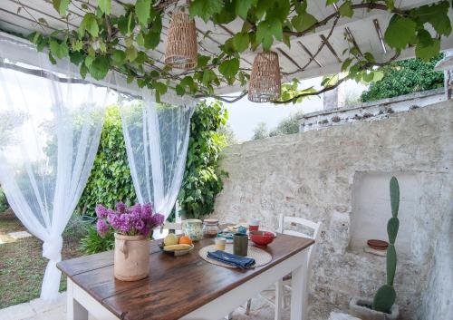 ein Tisch in einem Außenraum mit einer Steinmauer in der Unterkunft Il Trullo di Ben in Locorotondo