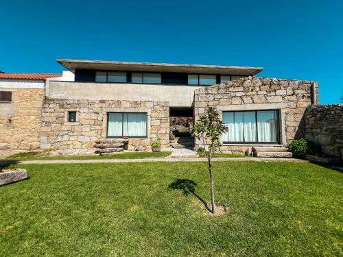 a stone house with a small tree in the yard at Casas da Fonte in Viana do Castelo