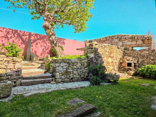 a stone building with stairs and a tree at Casas da Fonte in Viana do Castelo