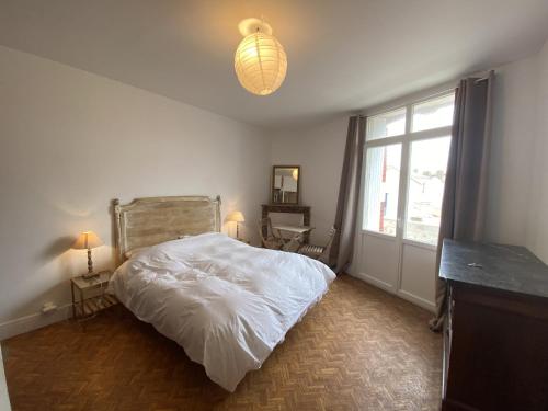 une chambre avec un lit blanc et une fenêtre dans l'établissement Maison familiale de vacances, à La Rudelière