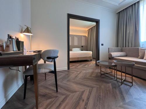 a hotel room with a desk and a bedroom at Royal Garden Assago Milano in Assago