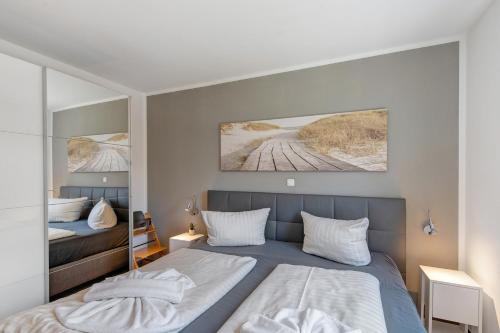 a bedroom with a bed and a mirror at Haus Seeblick in Göhren-Lebbin