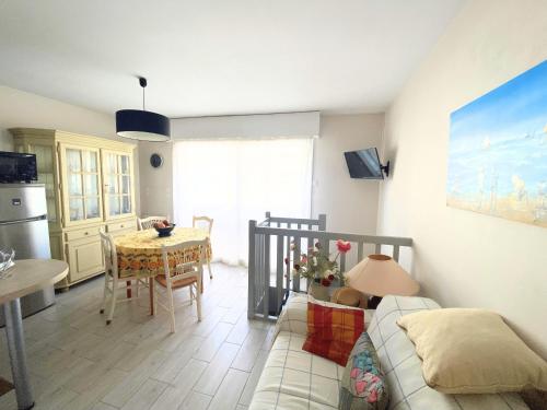 un salon avec un canapé et une table et une cuisine dans l'établissement Le Petit Faure appartement 50m de la mer, à La Rudelière