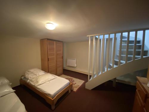 une petite chambre avec un lit et un escalier dans l'établissement Le Petit Faure appartement 50m de la mer, à La Rudelière