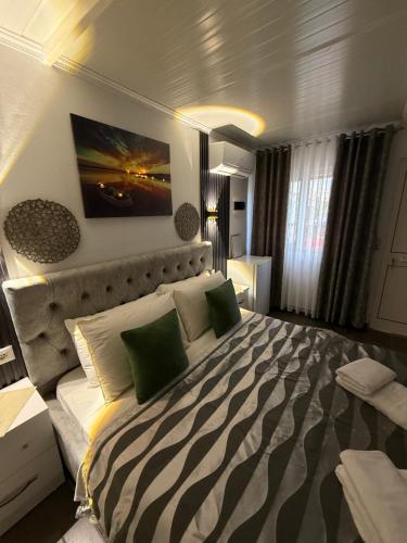 a bedroom with a large bed with green pillows at Mayfair Apartment Ksamil in Ksamil