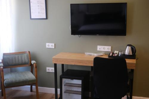 a desk with a television on a wall with a chair at Balta Hotel in Edirne