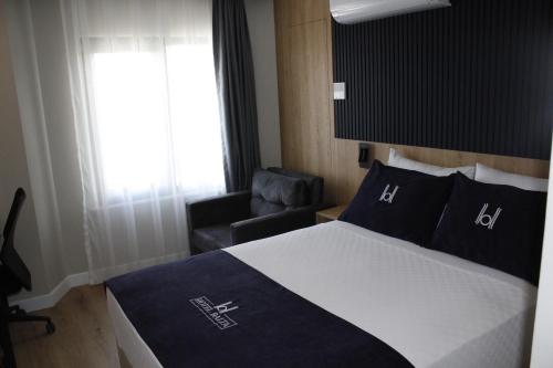 a bedroom with a bed and a chair and a window at Balta Hotel in Edirne