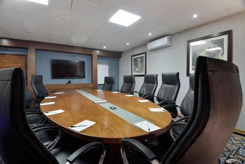 a conference room with a large wooden table and chairs at Kwa Maritane Lodge in Ledig