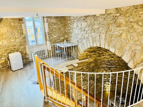 a room with a stone wall with a bridge at Charme unique sous les remparts in Châteauneuf-de-Gadagne