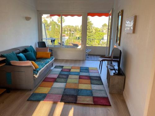 - un salon avec un canapé et un tapis coloré dans l'établissement Appartement moderne avec vue mer à Cannes, à Cannes