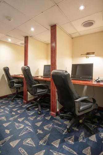 an office with three desks with chairs and a television at The Portswood Hotel in Cape Town