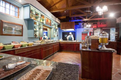 a large kitchen with people preparing food in a restaurant at The Portswood Hotel in Cape Town