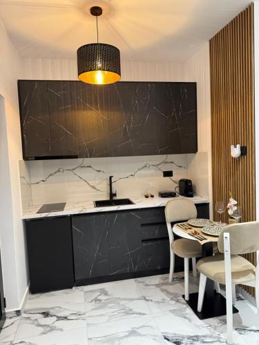 a kitchen with a sink and a table with chairs at Vila La Familia in Ksamil