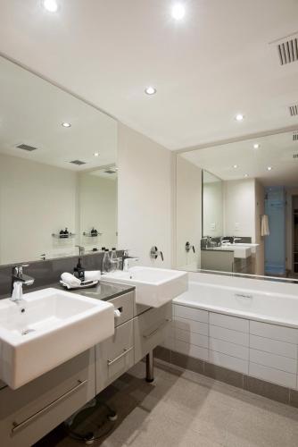 a bathroom with two sinks and a tub and a mirror at The Portswood Hotel in Cape Town