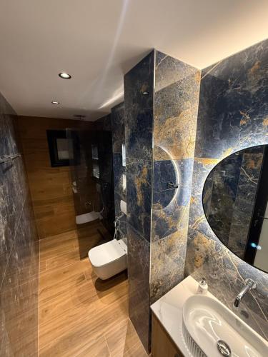 a bathroom with a sink and a toilet and a mirror at Vila La Familia in Ksamil
