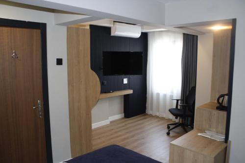 a room with a tv and a desk with a chair at Balta Hotel in Edirne