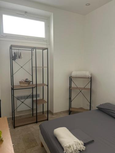 - une chambre avec un lit, une fenêtre et des étagères dans l'établissement Entire studio Cannes Raphael, à Cannes