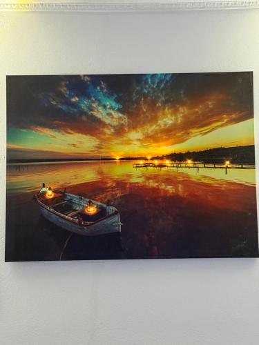 a boat sitting on the beach at sunset at Mayfair Apartment Ksamil in Ksamil