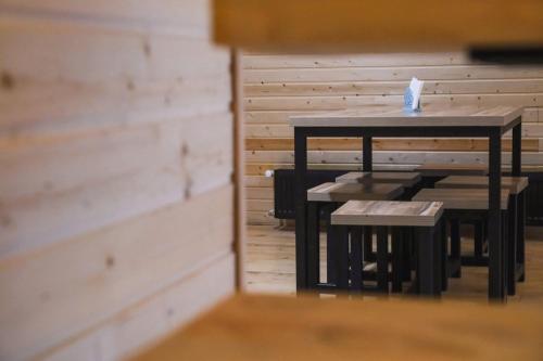 a table and benches in a room with a wall at Park Hotel Surami Chalet in Surami
