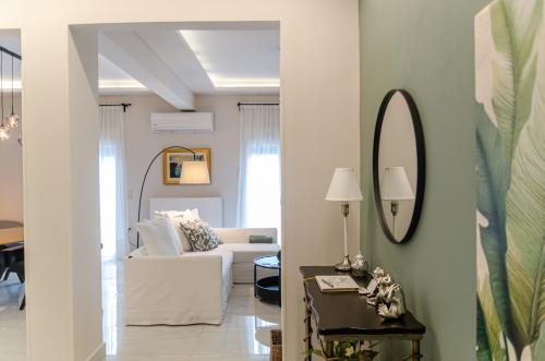 a living room with a white couch and a mirror at Green apartment in Piraeus