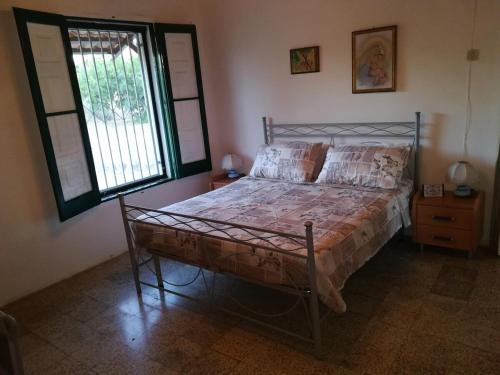 a bedroom with a bed and a window at Villa Cenate in Nardò