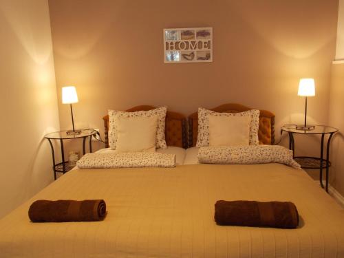 a bedroom with a large bed with two pillows at Éden Villa Apartmanház in Balatonfüred