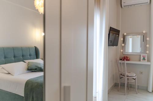 a bedroom with a bed and a mirror and a chair at Green apartment in Piraeus