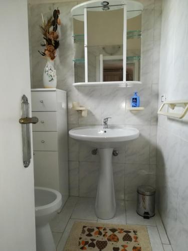 a white bathroom with a sink and a mirror at Villa Cenate in Nardò
