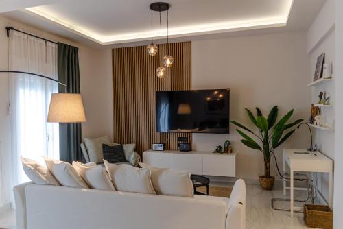a living room with a white couch and a tv at Green apartment in Piraeus