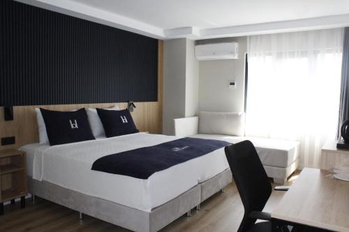 a bedroom with a large bed and a desk at Balta Hotel in Edirne