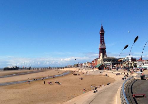 a group of people on the beach near the eiffel tower at Adina Hotel in Blackpool