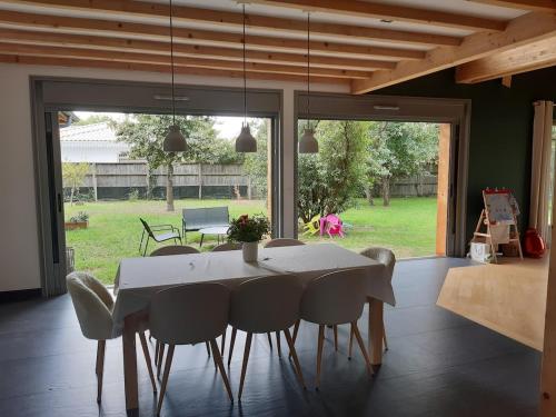 une salle à manger avec une table et des chaises blanches dans l'établissement Pretty House in Lège Bourg, à Lège-Cap-Ferret